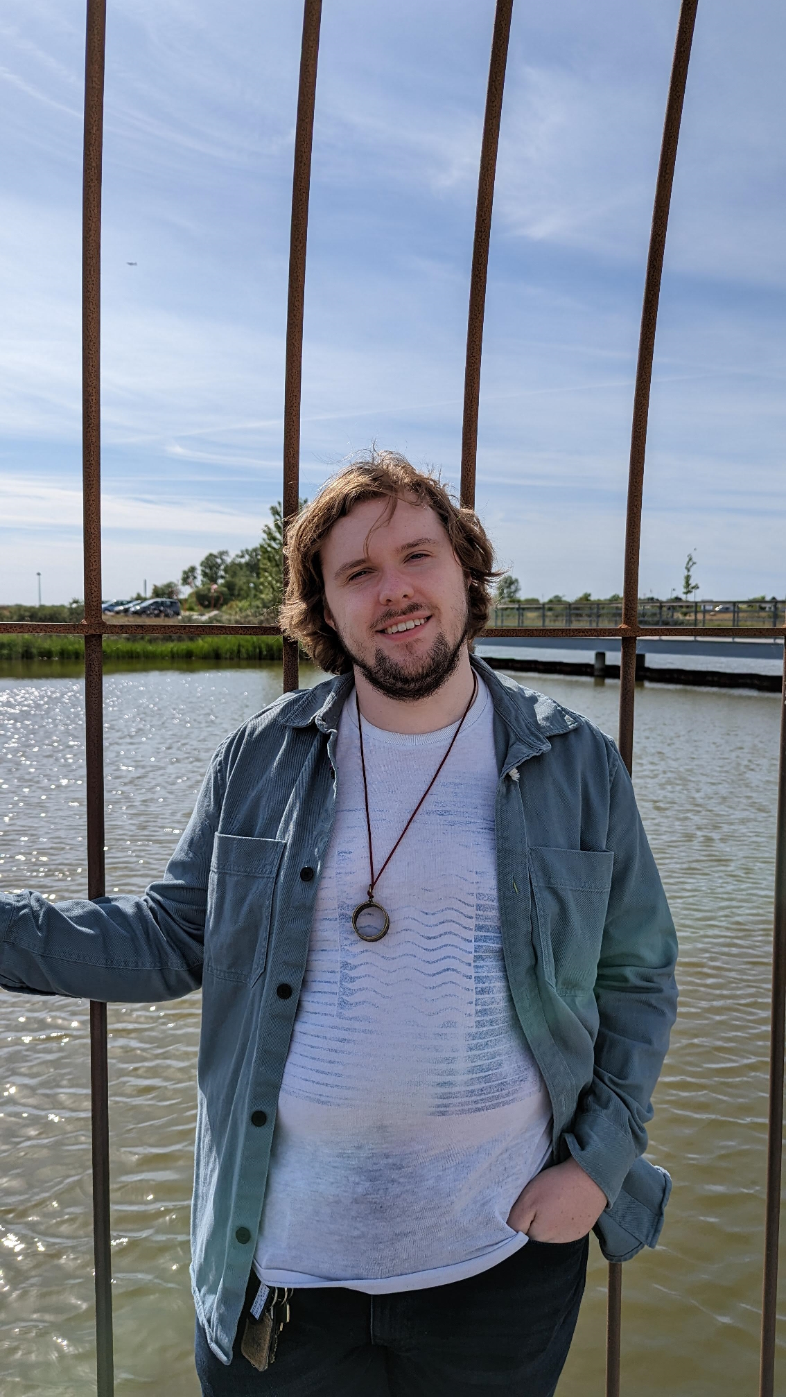 Me, standing in front of some metal bars, with water and sky in the background
